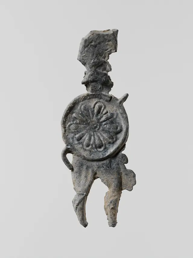Lead figure of a warrior with a helmet, shield, and spear
