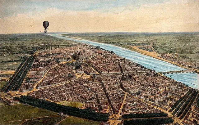 A hot-air balloon travels over a landscape giving an aerial